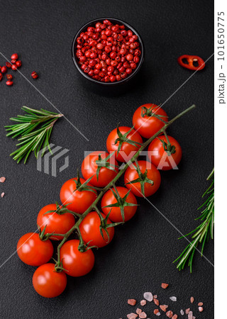 Delicious fresh cherry tomatoes on a twig on a dark concrete background Delicious fresh cherry tomatoes on a twig on a dark concrete background 101650775