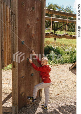 Funny cute happy baby playing on the playground. The emotion of happiness, fun, joy. Smile of a child. boy playing on the playground Funny cute happy baby playing on the playground. The emotion of happiness, fun, joy. Smile of a child. boy playing on the playground 101650799