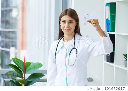 Woman doctor white uniform hold purple ribbon on hand symbol of Pancreatic cancer awareness 101652017
