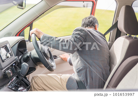 駐車場で自動車のドアを開けてバックする高齢者ドライバーの男性 駐車場で自動車のドアを開けてバックする高齢者ドライバーの男性 101653997