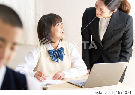 教室で授業を受ける中学生と指導する先生 101654071
