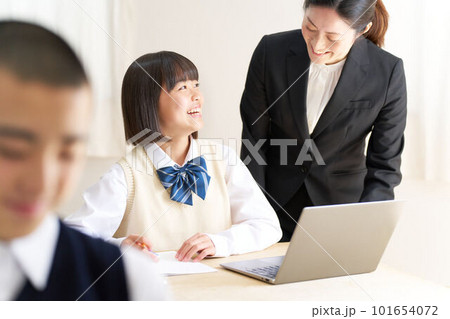 教室で授業を受ける中学生と指導する先生 101654072