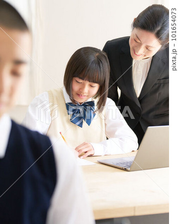 教室で授業を受ける中学生と指導する先生 101654073