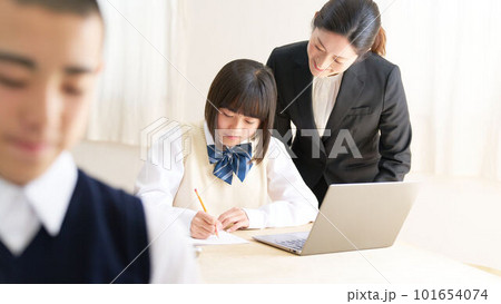 教室で授業を受ける中学生と指導する先生 101654074
