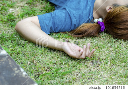 Young Asian woman fainting on grass in park in summer because outdoors of hot weather 101654216