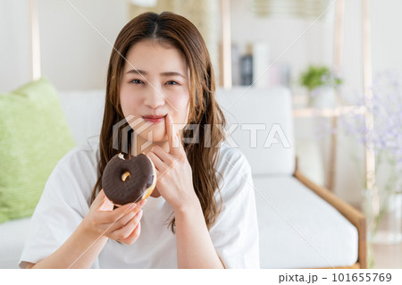 ドーナツを食べる若い女性 101655769
