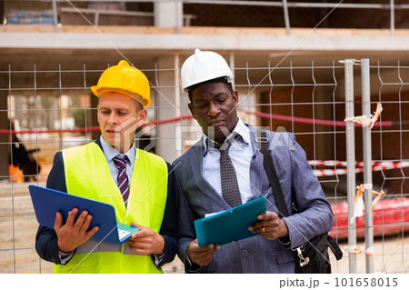 Architect and foreman must write documents and drawings on laptop with building construction 101658015