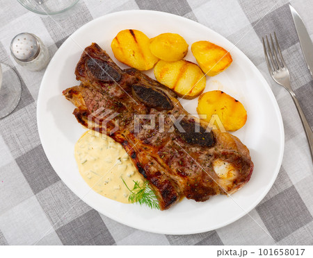 Churrasco style grilled veal ribs with potatoes and sauce Churrasco style grilled veal ribs with potatoes and sauce 101658017