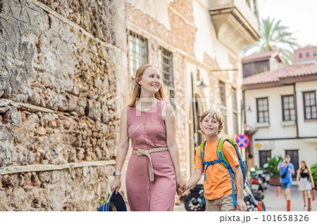 Mom and son tourists in Old town Kaleici in Antalya. Turkiye. Panoramic view of Antalya Old Town port, Taurus mountains and Mediterrranean Sea, Turkey. Traveling with kids concept 101658326