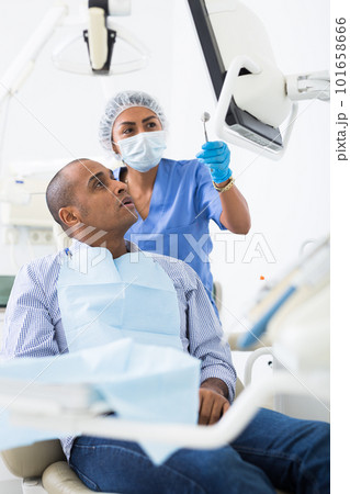 Woman dentist shows patient an x-ray 101658666