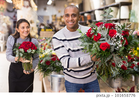 Owner of flower shop advising male customer before purchase of flowers Owner of flower shop advising male customer before purchase of flowers 101658776