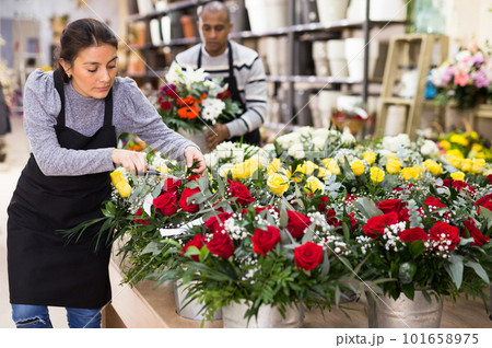 Florist in an apron creates bouquets in flower shop 101658975