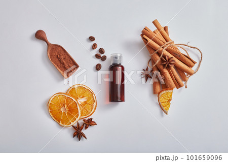Flat lay cosmetic mockup with brown bottle without label, cinnamon sticks, anise, dried orange slices and coffee on white background. Health herbs, headache relief and reduce stress 101659096