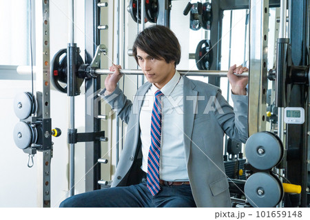 スーツ姿でウエイトトレーニングする若い男性 スーツ姿でウエイトトレーニングする若い男性 101659148