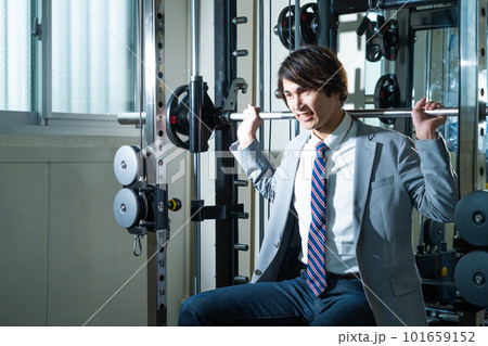 スーツ姿でウエイトトレーニングする若い男性 101659152