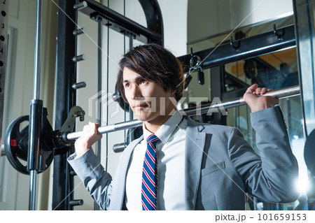 スーツ姿でウエイトトレーニングする若い男性 スーツ姿でウエイトトレーニングする若い男性 101659153