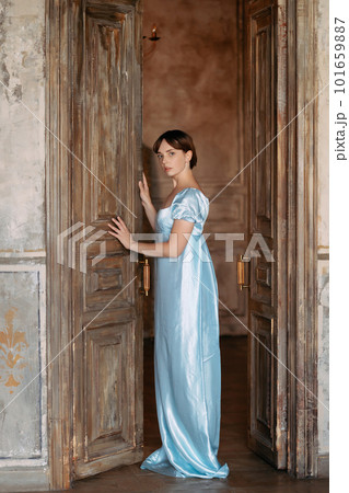 A young beautiful girl in a Regency blue dress 101659887