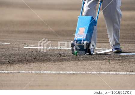 野球の試合前のグランドでバッターボックスに白線を引く整備員 101661702