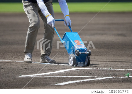 野球の試合前のグランドでバッターボックスに白線を引く整備員 101661772