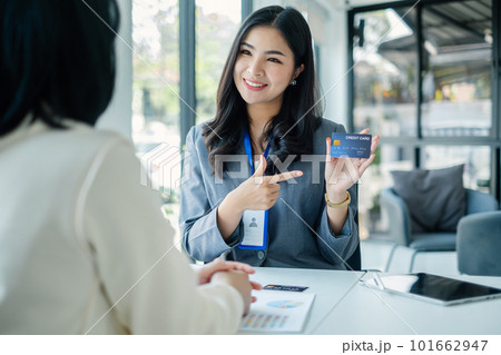 Asian business customer service representatives work and smile serve sell credit card to customers. choosing insurance plan in office 101662947