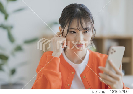 スマホを見ながら考え込む若い女性 スマホを見ながら考え込む若い女性 101662982