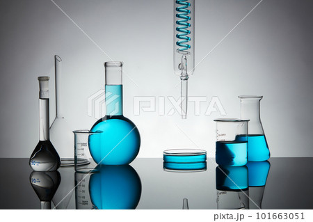 Minimal art background with petri dish, beaker, erlenmeyer flask, boiling flask and lab glassware containing blue liquid on back lit background. Minimal art background with petri dish, beaker, erlenmeyer flask, boiling flask and lab glassware containing blue liquid on back lit background. 101663051