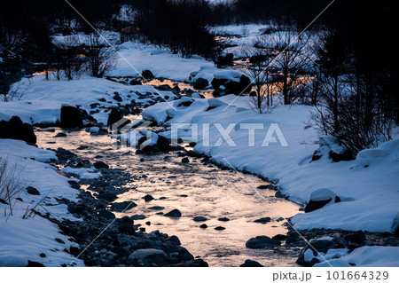 冬の川の川面に映り込む雪景色 冬の川の川面に映り込む雪景色 101664329