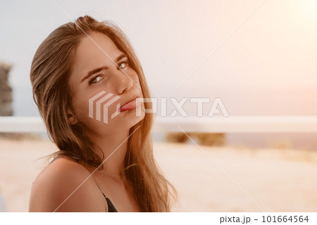 Happy woman portrait in cafe. Boho chic fashion style. Outdoor photo of young happy woman with long hair, sunny weather outdoors sitting in modern cafe. 101664564