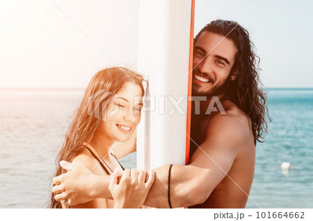 Woman man sea sup. Close up portrait of beautiful young caucasian woman with black hair and freckles looking at camera and smiling. Cute woman portrait in a pink bikini posing on sup board in the sea. Woman man sea sup. Close up portrait of beautiful young caucasian woman with black hair and freckles looking at camera and smiling. Cute woman portrait in a pink bikini posing on sup board in the sea. 101664662