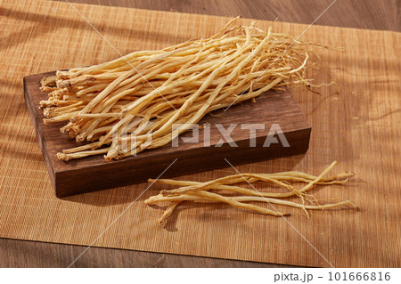A rectangle wooden podium with Dangshen placed on, decorated with bamboo blinds. Dangshen (codonopsis pilosula) helps the body to get more energy, improve health as well as support weight gain. 101666816