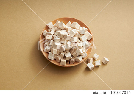 A plate of Chinese medicinal herbs of wolfiporia extensa or poria cocos on round dishes on light brown background. Herb has many effects: anti-oxidant, anti-cancer, anti-viral 101667014