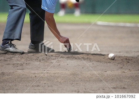 野球の試合中の攻守交代時にマウンドのピッチャープレートをきれいにする審判の手元 野球の試合中の攻守交代時にマウンドのピッチャープレートをきれいにする審判の手元 101667092