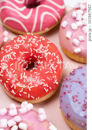 Donuts with red and pink glaze, top view. Lots of donuts, sweet and delicious food 101667987