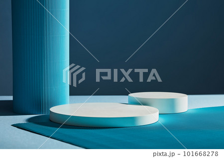 Front view of two white round empty podiums on dark blue background. Minimal art background with copy space for cosmetics product presentation 101668278