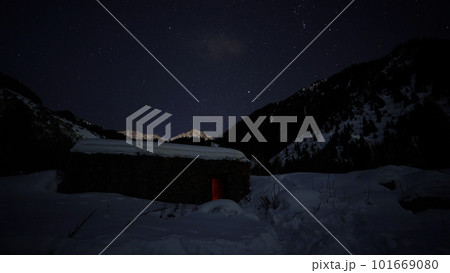 The night starry sky and a hut in the mountains 101669080