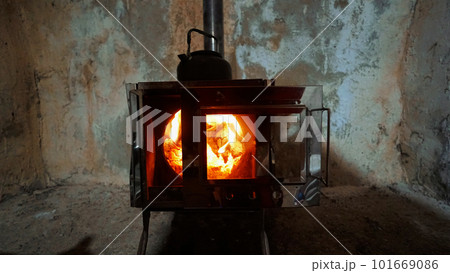 A fire in a camping stove with a glass door. A fire in a camping stove with a glass door. 101669086