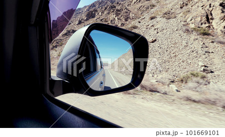 View of the road in the side mirror of the car. 101669101