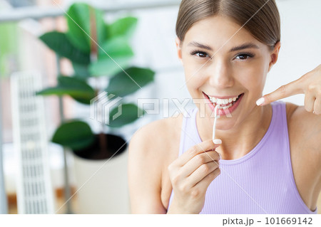 Cleaning teeth with dental floss, perfect healthy tooth 101669142