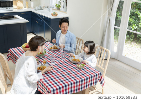 会話をしながら食事をする若い家族 会話をしながら食事をする若い家族 101669333