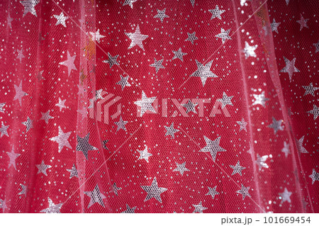Transparent tulle background with glittering stars on red tulle 101669454