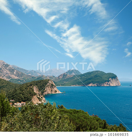 Picturesque view on rocks on a sunny day from the sea. Budva riviera, Montenegro. Aerial view of Sveti Nikola, Budva island, Montenegro. Hawaii beach, umbrellas and bathers and crystal clear waters 101669835