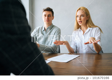 Rear view of unrecognizable male applicant introducing during job interview, talking about working experience, serious recruiters hr managers interviewing listening to candidate, considering cv resume 101670166