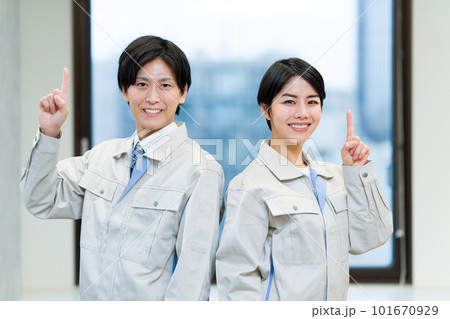 指差しをする作業服の男女 101670929