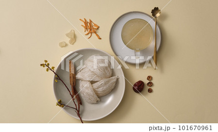 Advertising scene for product with raw bird nest, jujube, ginseng and cordyceps on beige background. Precious herbs are distilled with bird nest. Top view, flat lay. 101670961