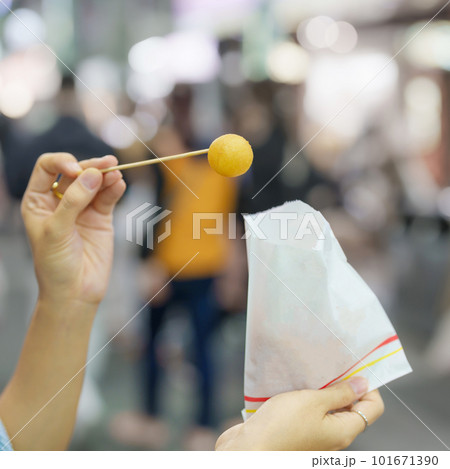 woman hand holding Sweet Potato Ball at night market, famous Taiwanese Street Food of Taiwan. exotic food in local market woman hand holding Sweet Potato Ball at night market, famous Taiwanese Street Food of Taiwan. exotic food in local market 101671390