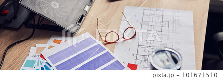 Close up shot of glasses, architectural blueprint with papers and color samples, thermos flask on creative desk Close up shot of glasses, architectural blueprint with papers and color samples, thermos flask on creative desk 101671510