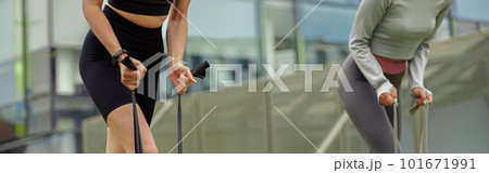 Close up of fit women trains leg muscles with fitness rubber bands in the city. Outdoor workout Close up of fit women trains leg muscles with fitness rubber bands in the city. Outdoor workout 101671991