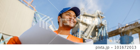 Smiling African engineer standing at industrial site 101672013