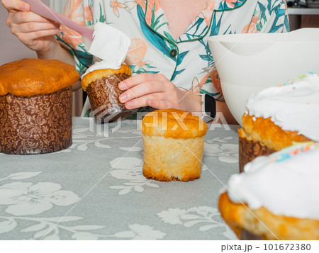 Spreading white icing on Easter cake. 101672380