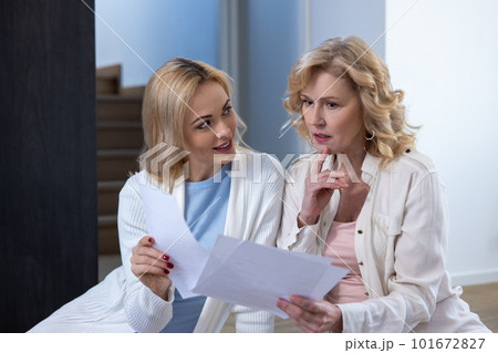 Joyous female showing papers to her puzzled colleague 101672827